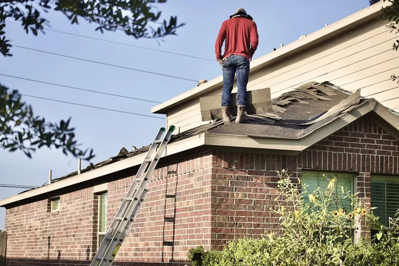 Professional roofer working on a residential roof in Carver-Kemp